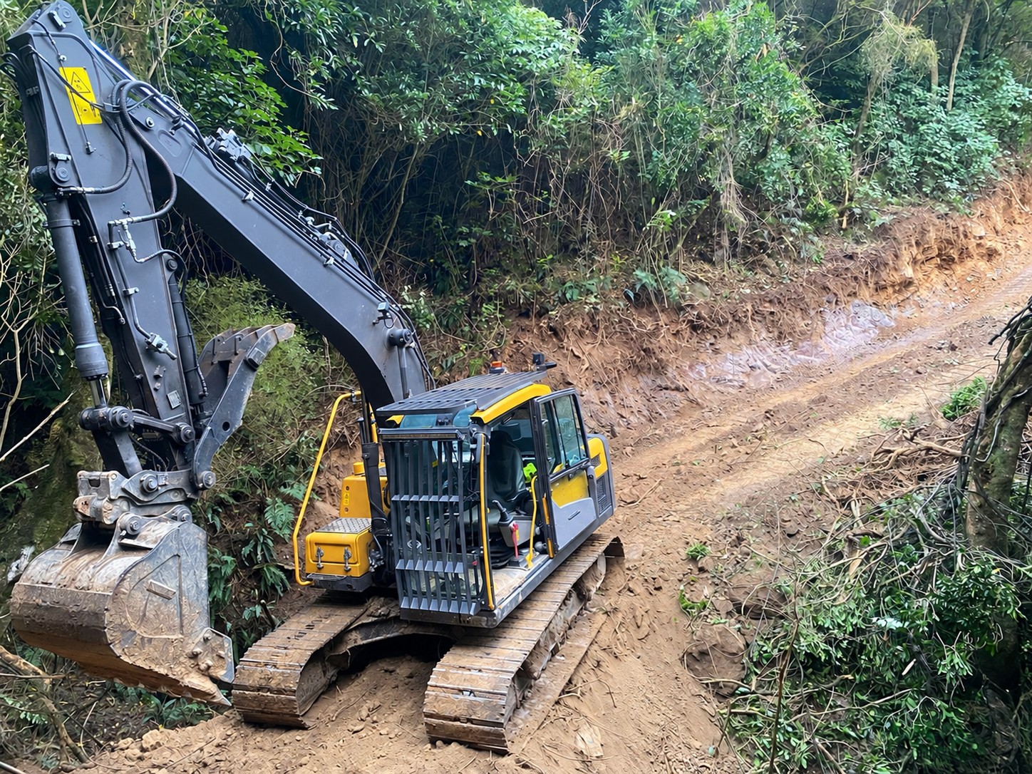 Excavator completing rural hillside earthworks